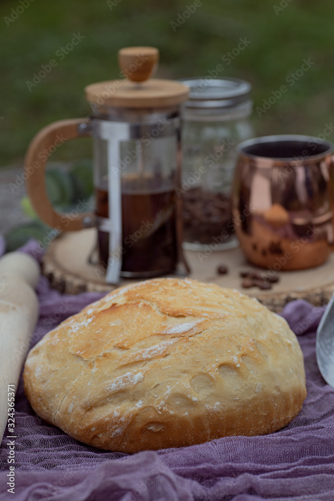 Artisan bread on tablecloth accompanied by coffee set