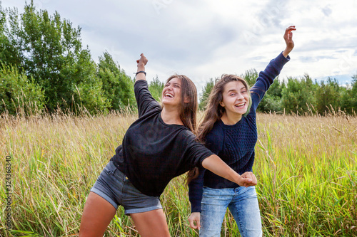 Summer holidays vacation happy people concept. Group of two girl friends dancing hugging and having fun together in nature outdoors. Lovely moments best friend. © Юлия Завалишина