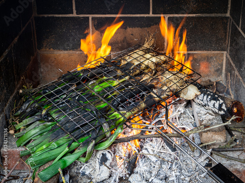 bunch of calcots (typical winter scallion or green onions from Catalonia) being cooked in a barbecue photo