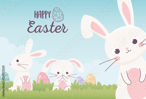 happy easter cute rabbits with decorative eggs in the grass