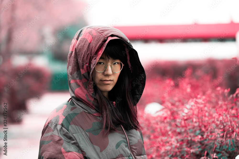 Chinese or asian woman with jacket and hood, red color, copy space Chinese or asian woman with jacket and hood, red color, copy space
