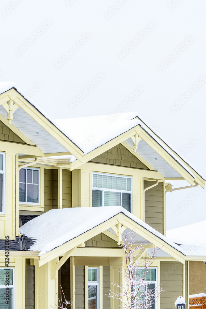 The top of a typical american home in winter. Snow covered roof and nice window.