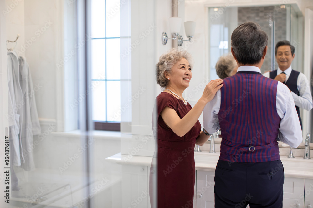 Happy senior Chinese couple getting dressed in bathroom Happy senior Chinese couple getting dressed in bathroom