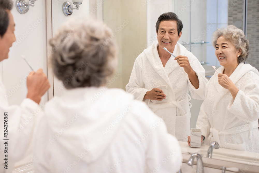 Happy senior Chinese couple brushing teeth in bathroom Happy senior Chinese couple brushing teeth in bathroom