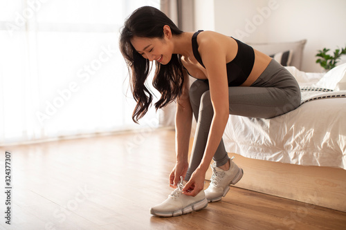 Happy young Chinese woman getting ready for morning exercise