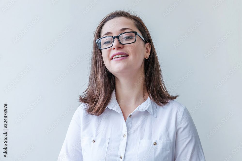 Beautiful happy girl smiling. Beauty simple portrait young smiling brunette woman in eyeglasses isolated on white background. Positive human emotion facial expression body language. Copy space