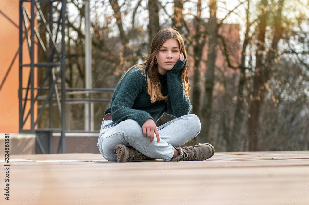 Obraz premium Portrait of a lonely sitting beautiful young teenage girl