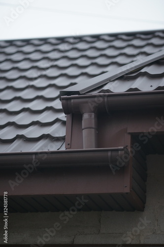 Closeup of brown tiled roof in grey sky