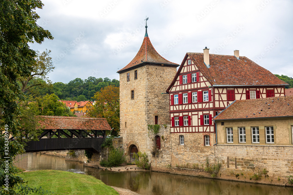Wooden covered bridge and old tower in the historic center of Schw bisch Hall on the Kocher river, Baden-Wurttemberg, Germany. Wooden covered bridge and old tower in the historic center of Schw bisch Hall on the Kocher river, Baden-Wurttemberg, Germany.