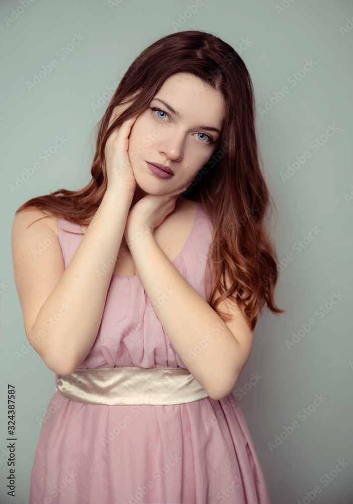 Young brunette in pink dress studio portrait Young brunette in pink dress studio portrait