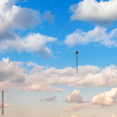 The rope of a construction cargo crane on a background of blue sky.
