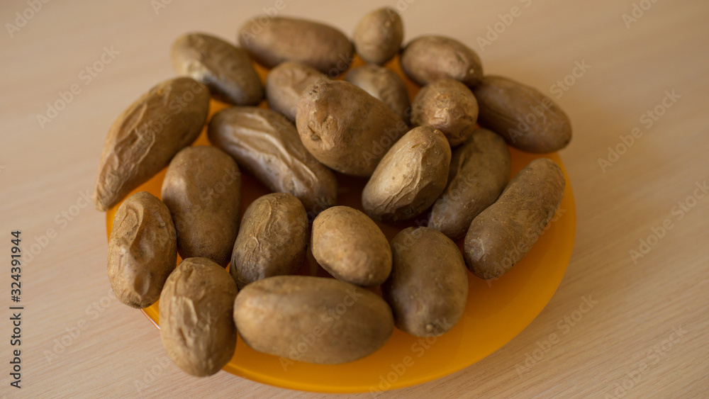 Many baked potatoes in a peel on an orange plate. Healthy food on the table. Many baked potatoes in a peel on an orange plate. Healthy food on the table.