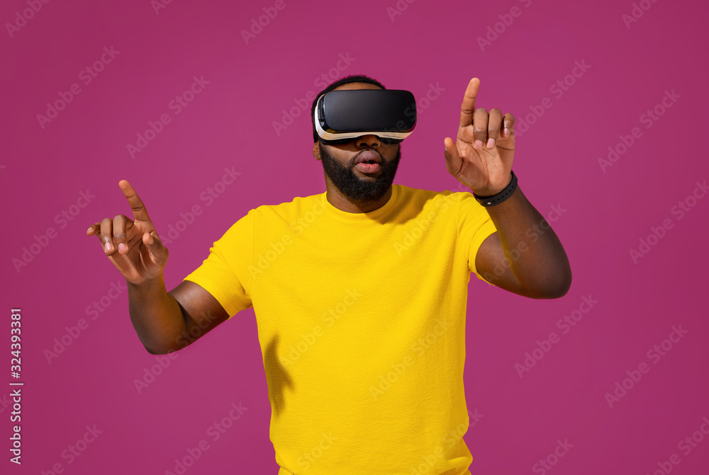 Naklejka premium Man touching air during the VR experience on purple background