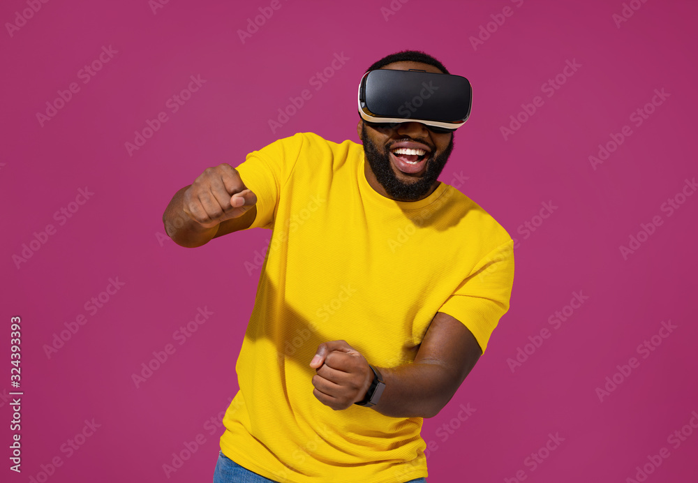 Man exploring new world of car races while wearing VR headset and gaming on purple background Man exploring new world of car races while wearing VR headset and gaming on purple background