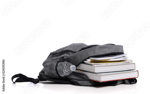 School backpack on a white background with books and spiral notebooks
