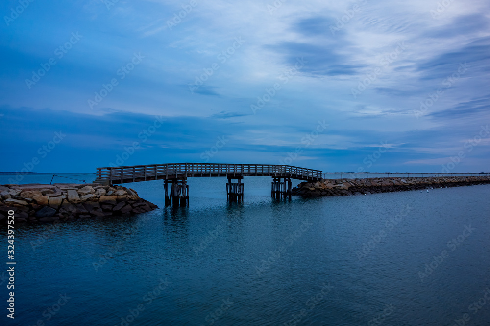 Plymouth wooden bridge on rock jetty during blue hours.