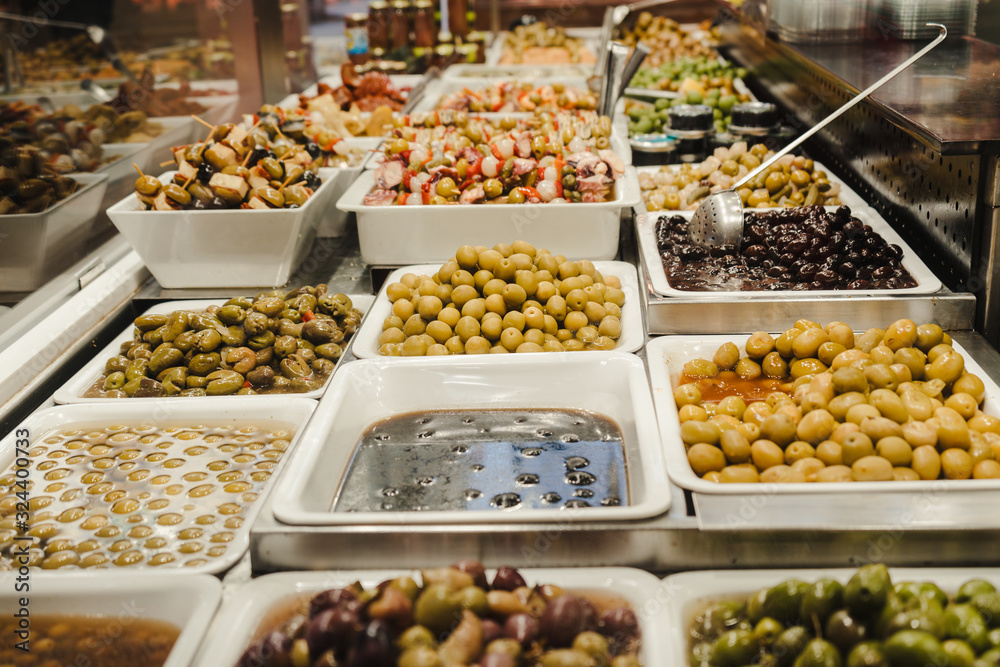 Assortment of olives, pickles and salads on market stand