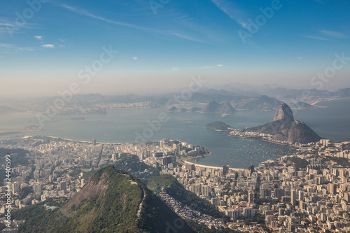 Panoramic view from Mirante Dona Marta looking over city of Rio de Janeiro with Sugarloaf Mountain & Guanabara Bay entering the Atlantic Ocean on a sunny day in Rio, Brazil, South America