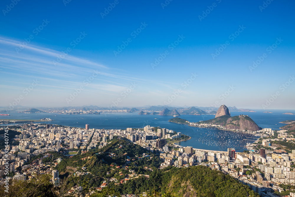 Panoramic view during daytime at Mirante Dona Marta looking across Rio de Janeiro with Sugarloaf Mountain & Guanabara Bay jutting out from the Atlantic Ocean on sunny day in Rio, Brazil, South America