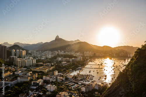 Beautiful sunset view from Sugarloaf mountain overlooking Botafogo & the city of Rio de Janeiro with the sun setting into the horizon and a bay with yachts and boats in Rio, Brazil, South America