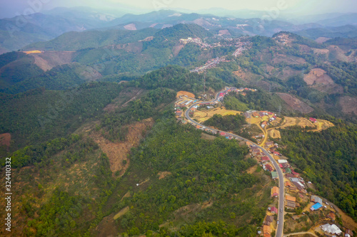 aerial scenic view of mountain road and rural village living along, in Laos. 