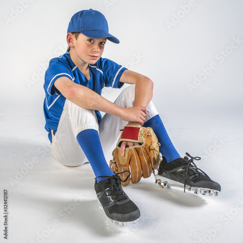 Canvas Print Young baseball player sitting and smiling after winning the game