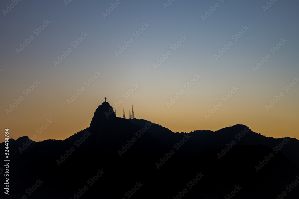 View of Christ the redeemer (Cristo Redentor) as a silhouette on top of Mount Corcovado just after sunset as nightfall begins in Rio de Janeiro, Brazil, South America