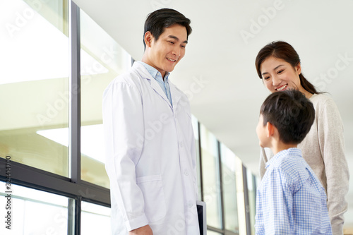 young asian doctor talking to mother and son in hospital