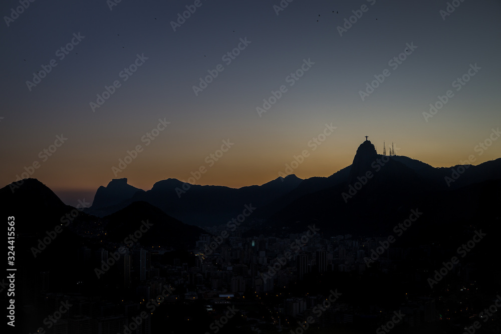 View of Christ the redeemer (Cristo Redentor) as a silhouette on top of Mount Corcovado just after sunset as nightfall begins in Rio de Janeiro, South America