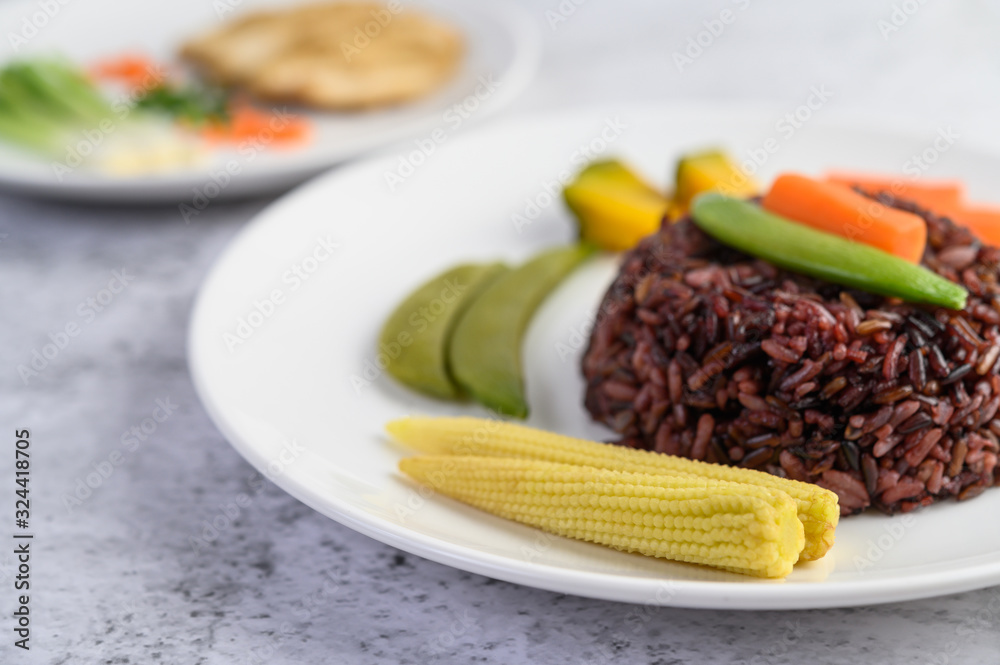 Black rice on a plate with pumpkin, peas, carrots, baby corn