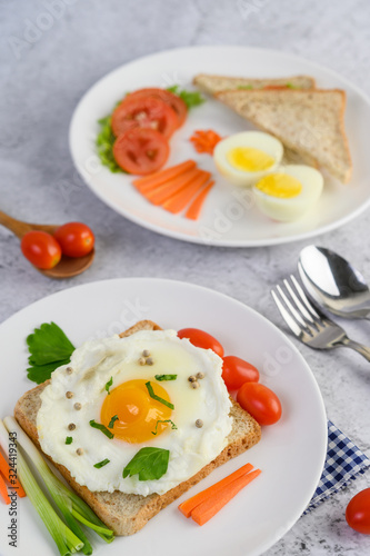 A fried egg laying on a toast  topped with pepper seeds with carrots  baby corn and spring onions.