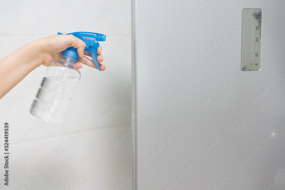Asian women cleaning and disinfecting refrigerator