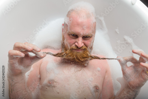 Obraz na plátne A bald man is fooling around in the foam bath