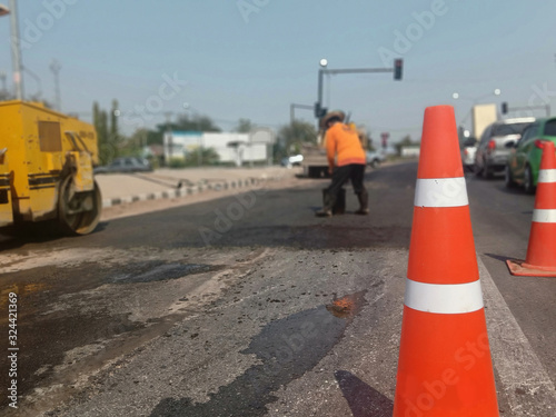 Pictures blurring red rubber cones and road construction workers