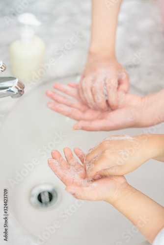 Young asian woman washing hands for her son