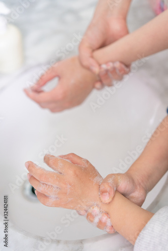 Young asian woman washing hands for her son © Allen Chen