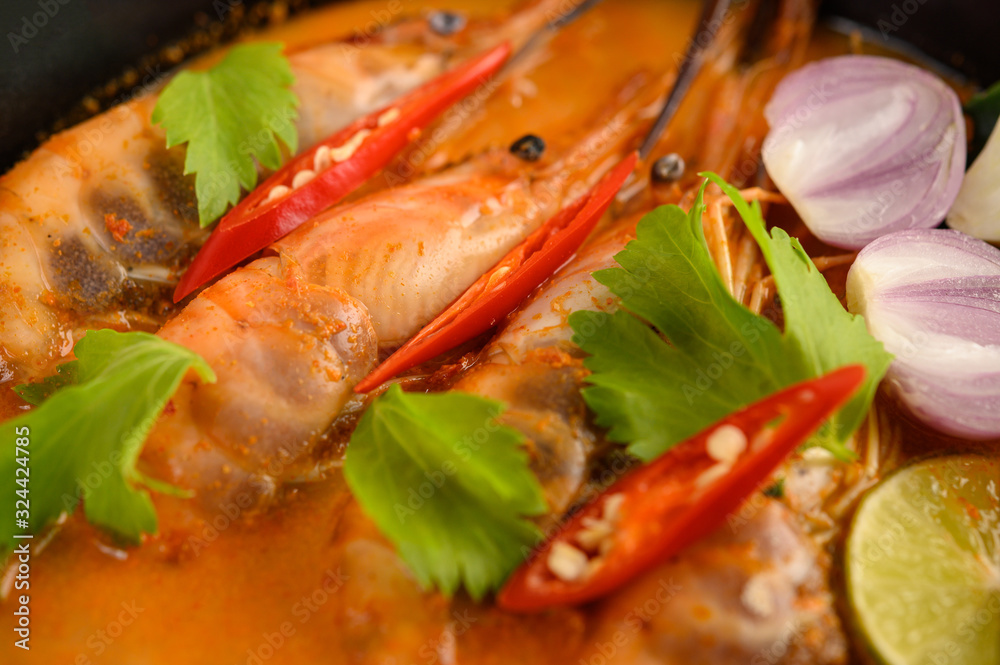 Tom Yum Kung Thai hot spicy soup shrimp with lemon grass,lemon,galangal and chilli on wooden background Thailand Food