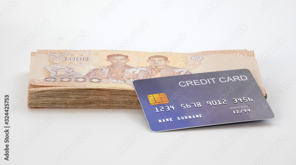 Close up blue credit cards are placed on the stack banknote. online shopping payment , Financial savings, and money wealth concepts. mockup and fake credit card. isolated on white background Close up blue credit cards are placed on the stack banknote. online shopping payment , Financial savings, and money wealth concepts. mockup and fake credit card. isolated on white background