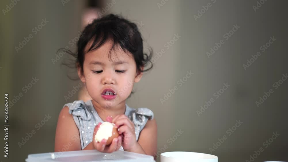 Little girl peeling boiled egg indoor. Learning at home. Little girl peeling boiled egg indoor. Learning at home.