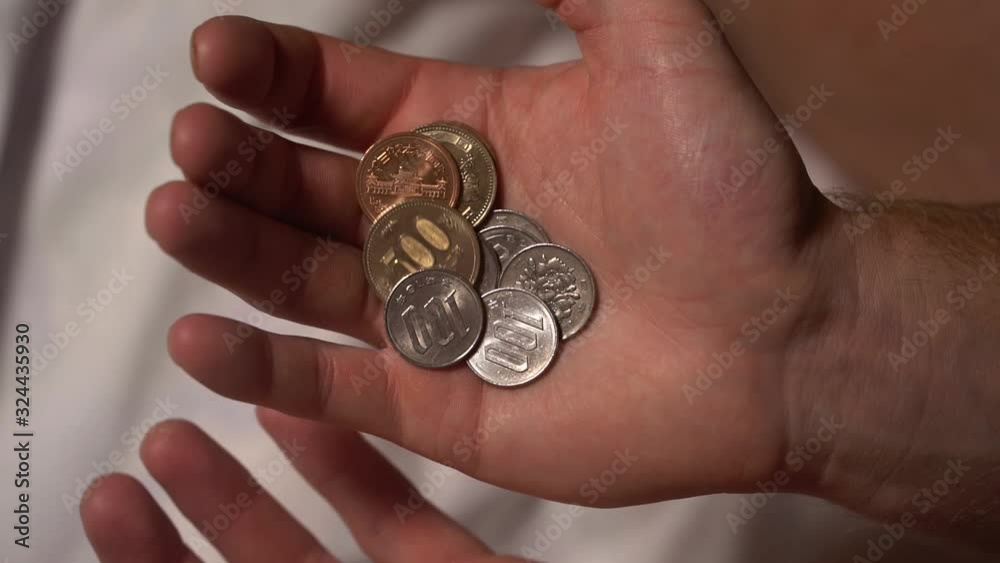 A close-up shot in slow-motion coins and money from Japan and Asia flowing from hand to hand. A close-up shot in slow-motion coins and money from Japan and Asia flowing from hand to hand.