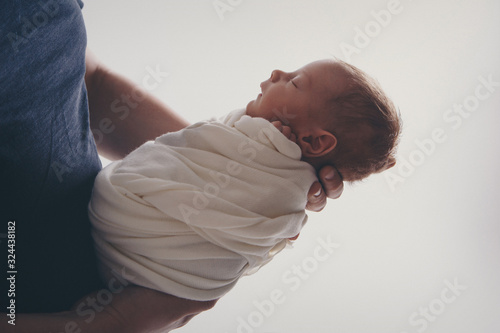 Newborn baby lying on hands of parents. Imitation of baby in womb. beautiful little girl sleeping on her back. manifestation of love. Health care concept, parenthood, children's Day, medicine, IVF