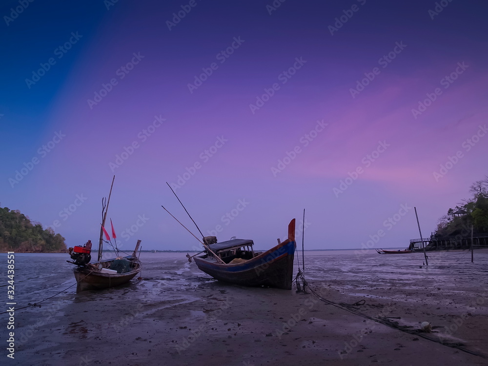 view seaside evening of long-tail boats floating seaside with purple sky background, sunset at Mu Ko Phetra National Park, pak nam, la-ngu district, Satun, Thailand.