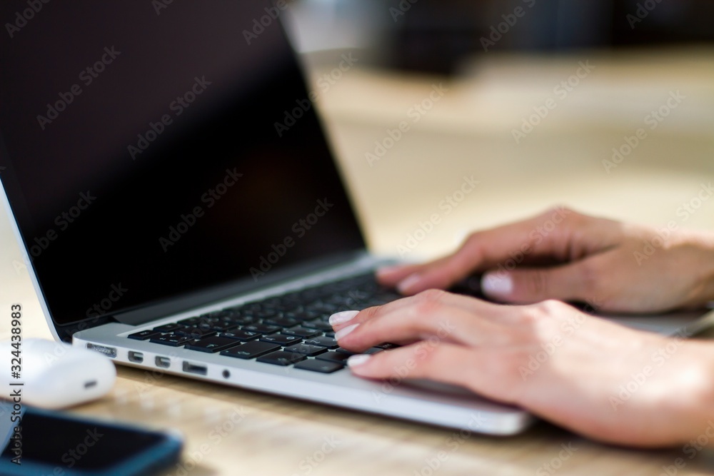 Businesswoman working with laptop keyboard and digital tablet in sunny office, business and technology concept. Close up Businesswoman working with laptop keyboard and digital tablet in sunny office, business and technology concept. Close up