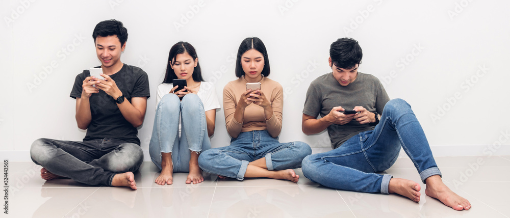 Fototapeta premium Group of friend sitting relax use technology together of smartphone checking social apps against copy space background.Communication concept