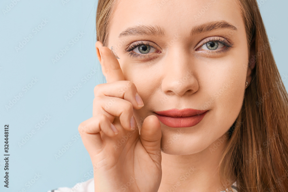 Young woman with contact lens on grey background, closeup Young woman with contact lens on grey background, closeup