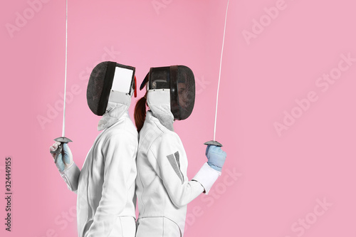 Young fencers on color background photo