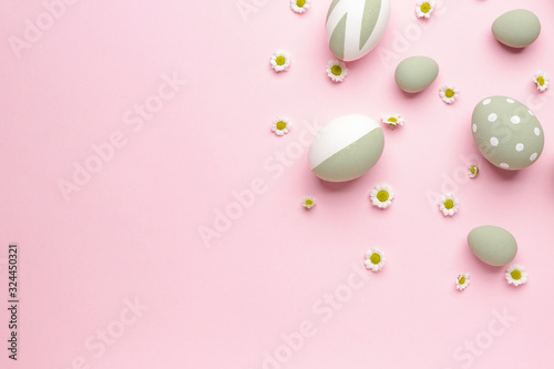 Beautiful Easter eggs and flowers on color background