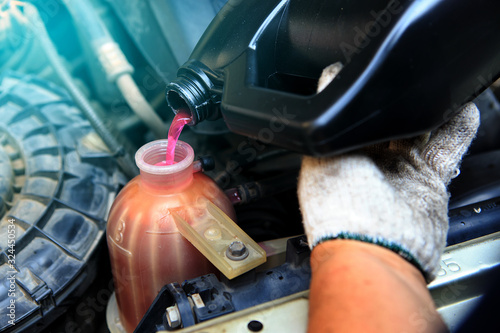 Photography A hand filling car cooling service in engine system with coolant