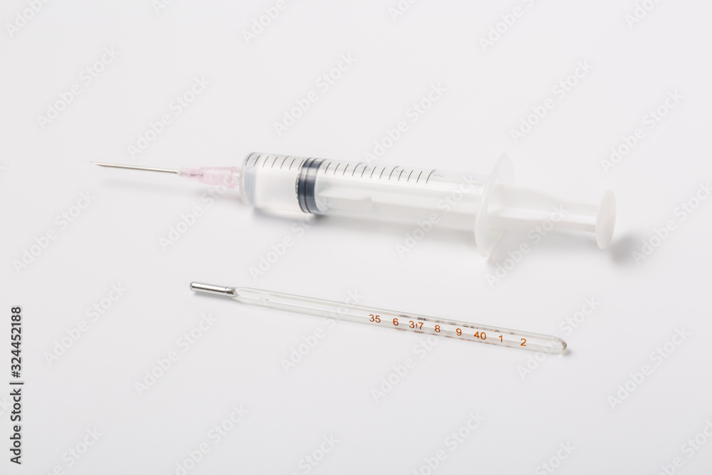 Syringe and miniature human and oral medicine and thermometer macro closeup on white background Syringe and miniature human and oral medicine and thermometer macro closeup on white background