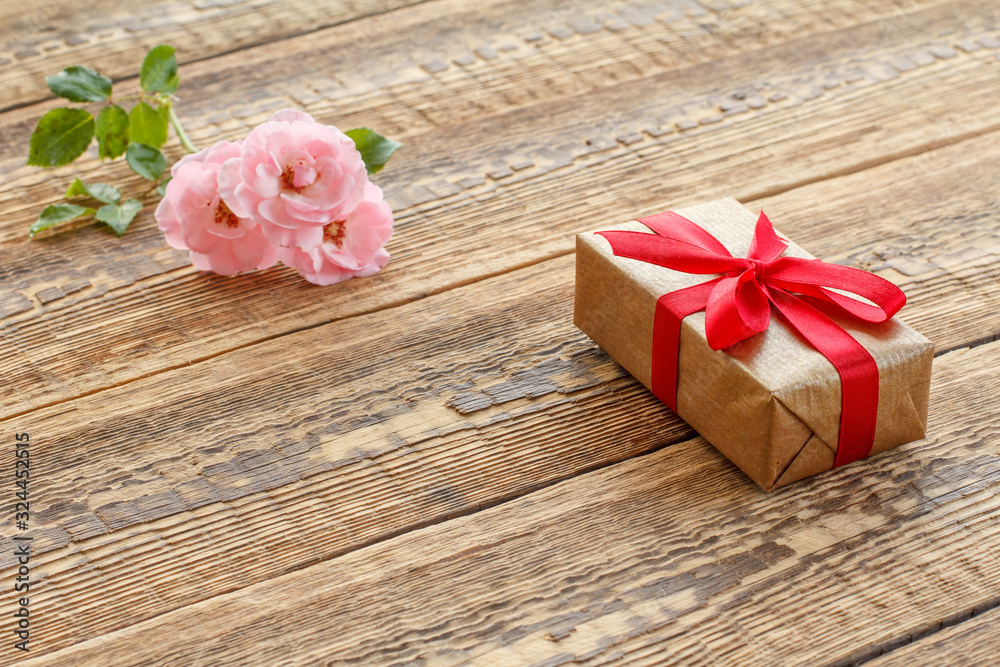 Gift box on wooden boards with pink roses Gift box on wooden boards with pink roses